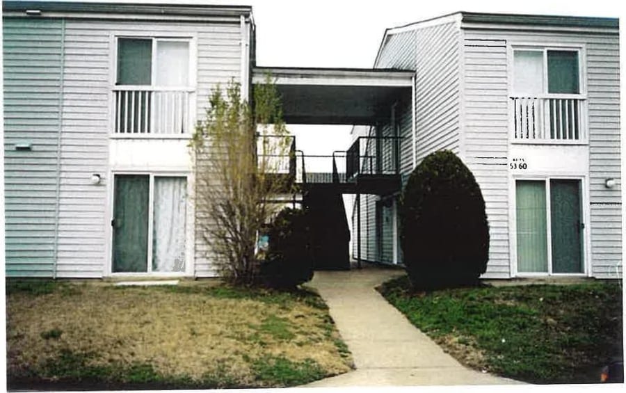 A paved walkway between two-story Village Green apartment buildings
